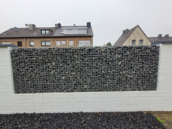 Steinkörbe im bestehenden Zaun Steinkörbe im bestehenden Zaun