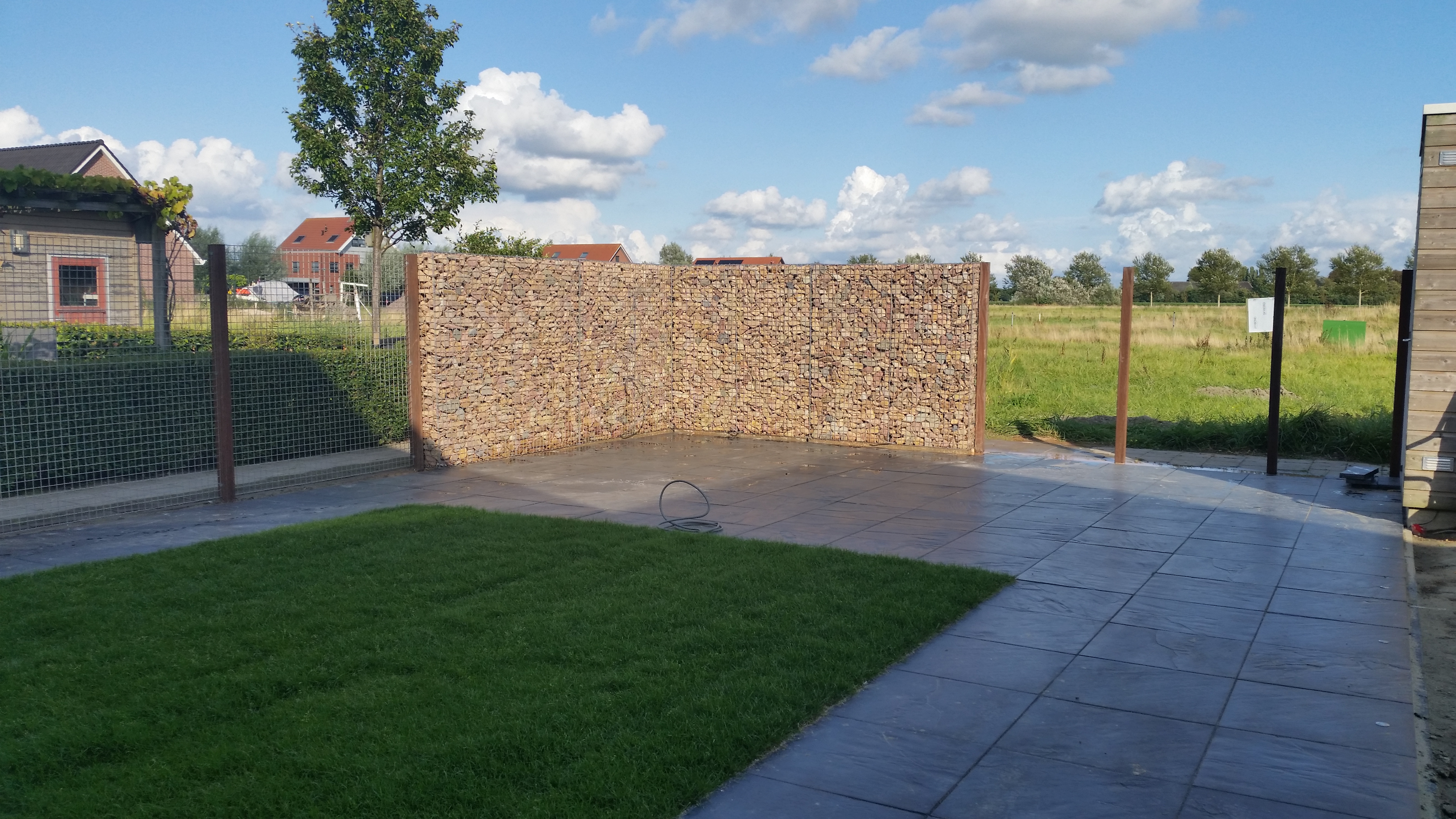 Gabionenwand mit Grauwacke-Bruchsteinen als Lärmschutz im Garten